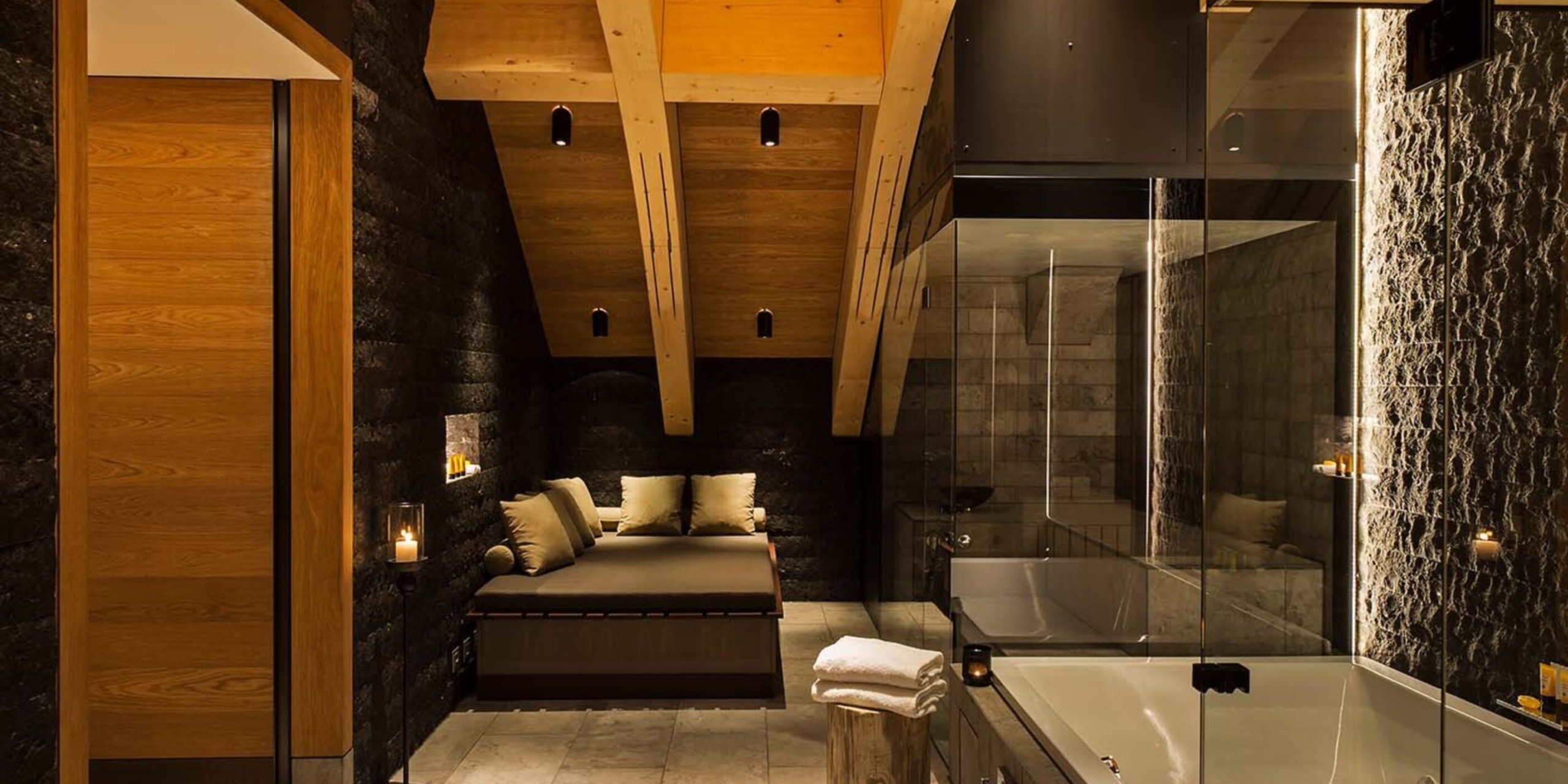 A candle-lit private spa suite with glass sauna built by Küng Wellness